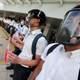 Students wearing gas masks join a human chain.